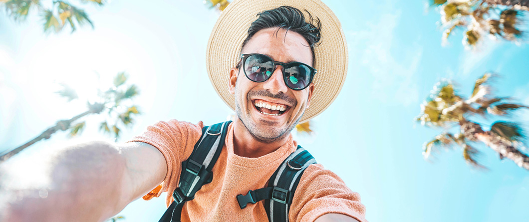 HappyTouristTakingSelfPortraitOutsideWithCellphoneOnSummer | Evok Advertising Effective Healthcare Marketing Beyond the Stigma